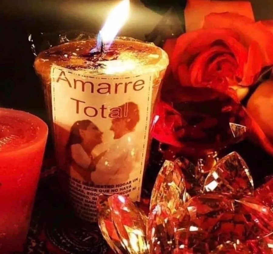 Vela ritual de amarre de amor encendida junto a rosas rojas y cristales, preparada para un trabajo energético